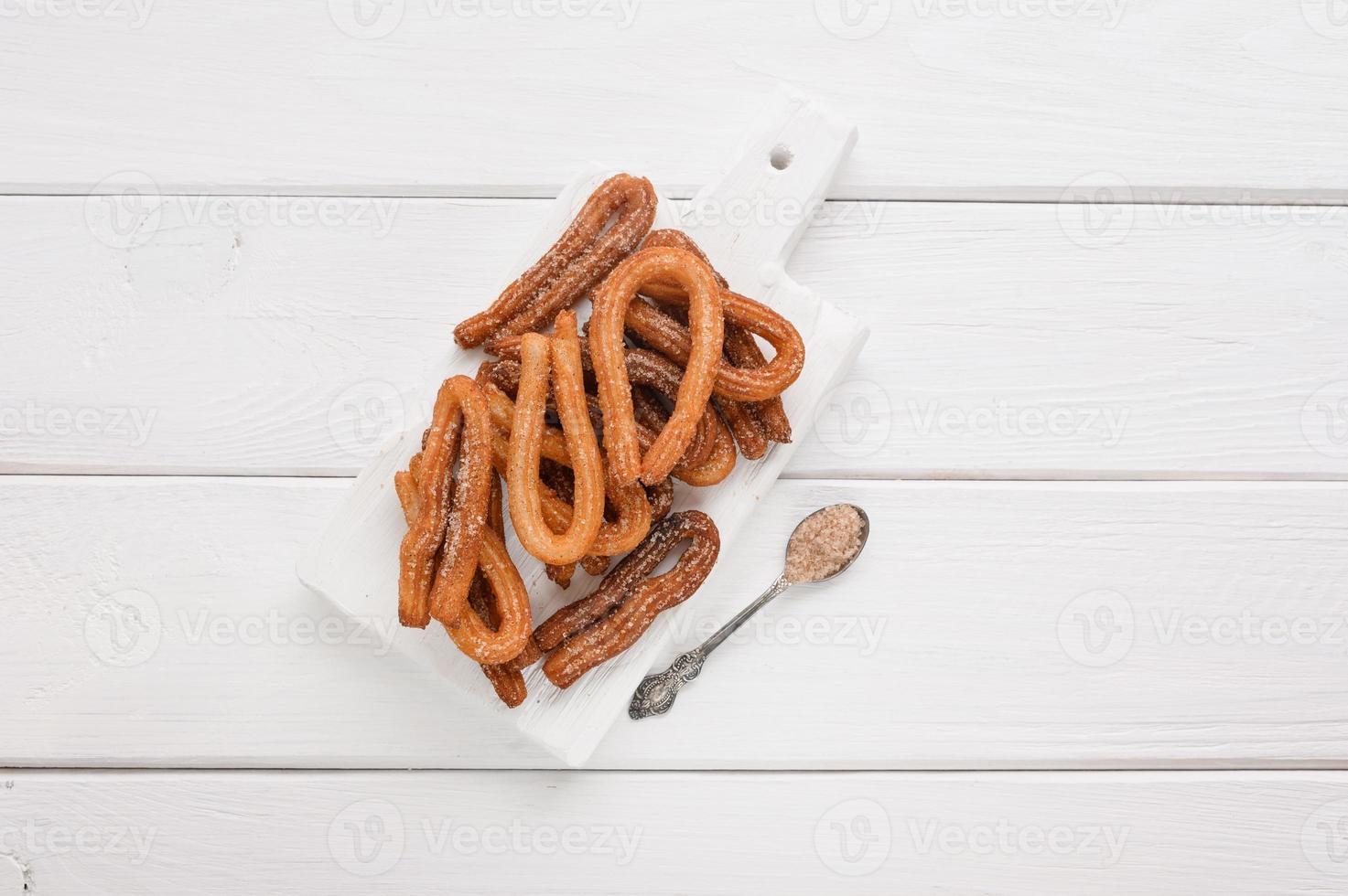 Homemade churros on a white wooden background. photo