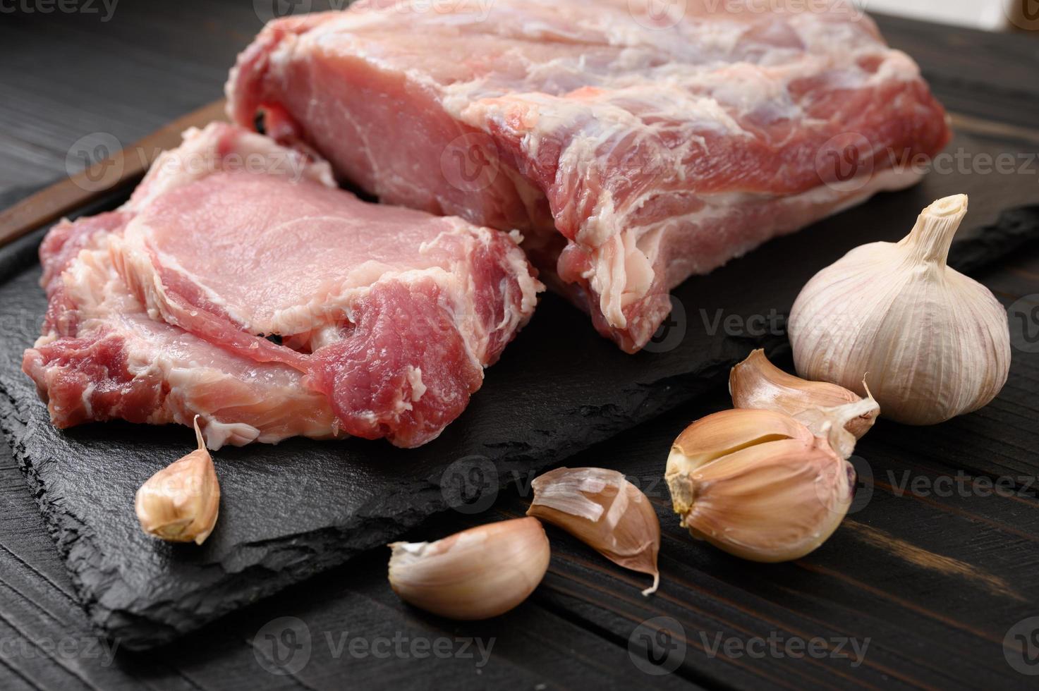 A large piece of pork loin on a rustic dark background. photo