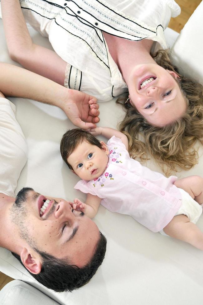 retrato interior con una familia joven feliz y un lindo bebé foto