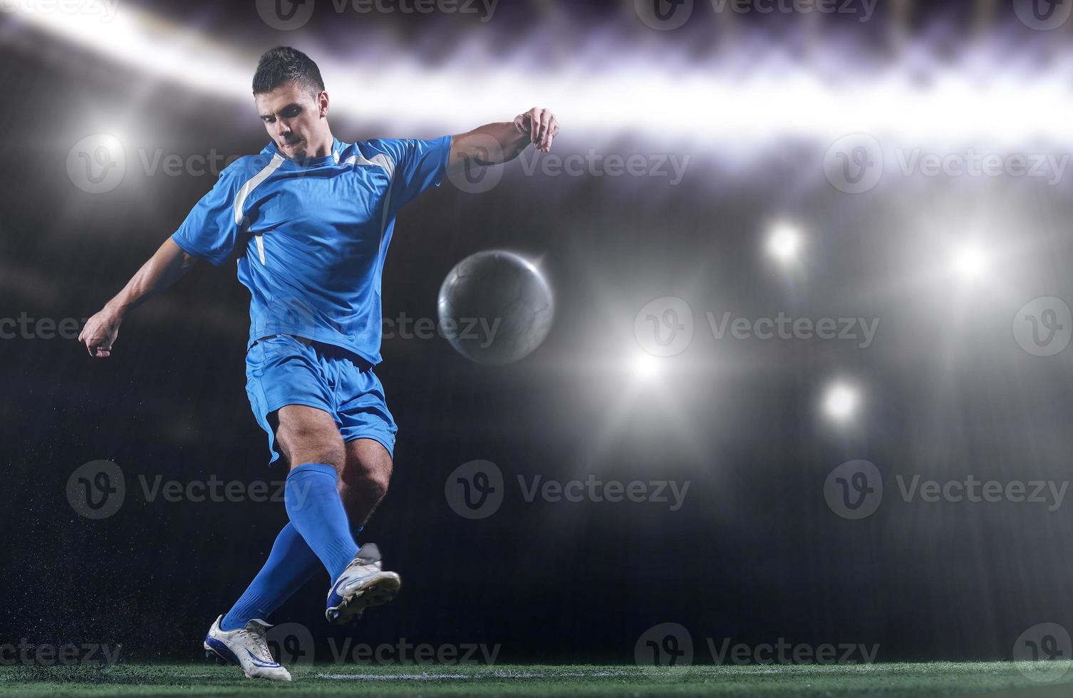 soccer player in front of big modern stadium with flares and lights photo