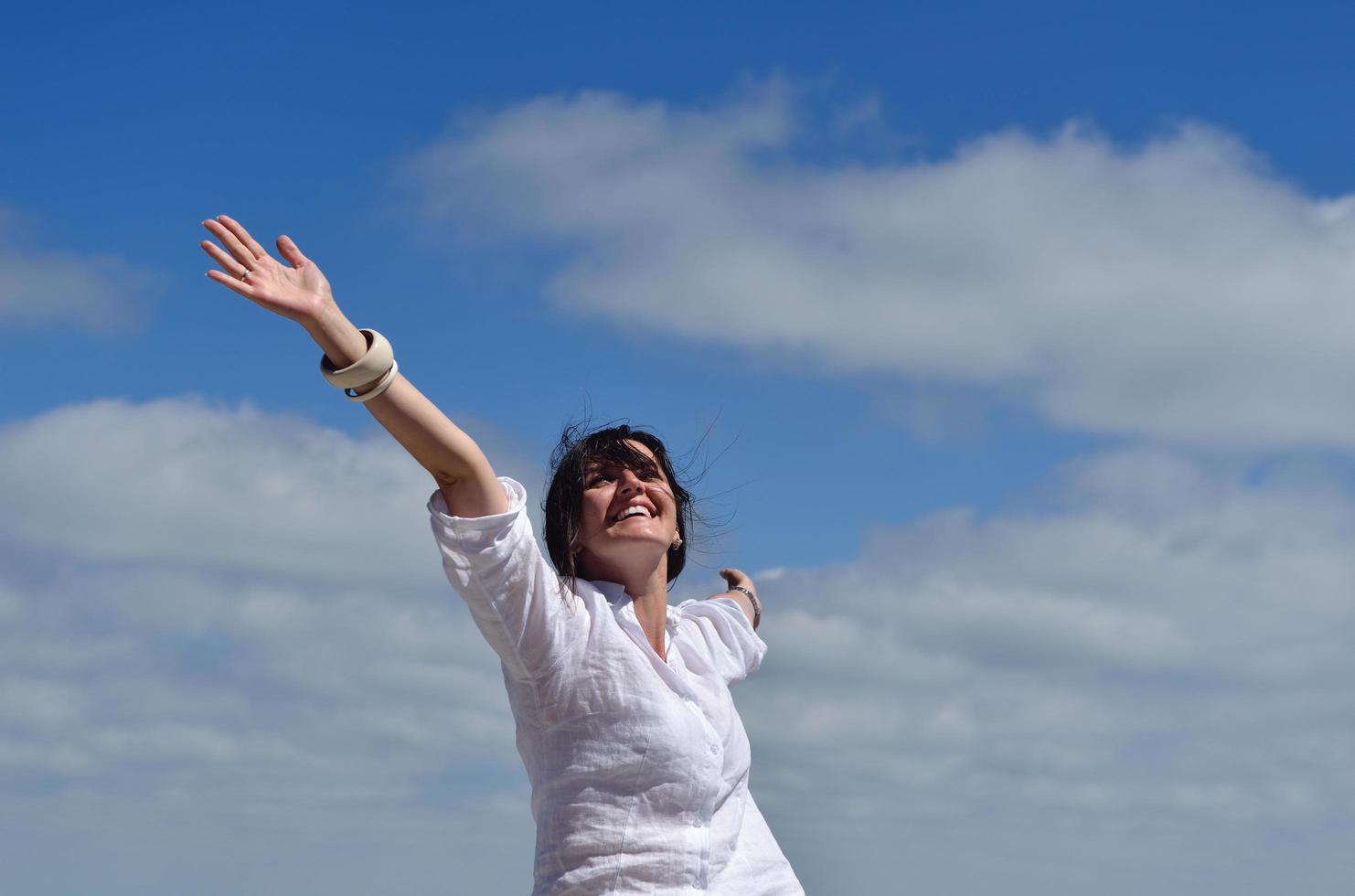 mujer joven feliz con los brazos extendidos al cielo foto