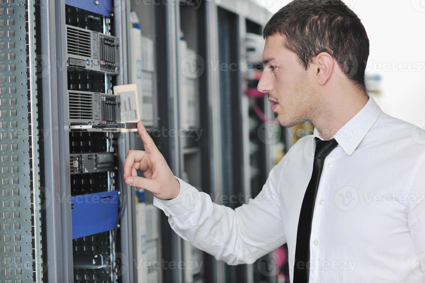 young engeneer in datacenter server room photo