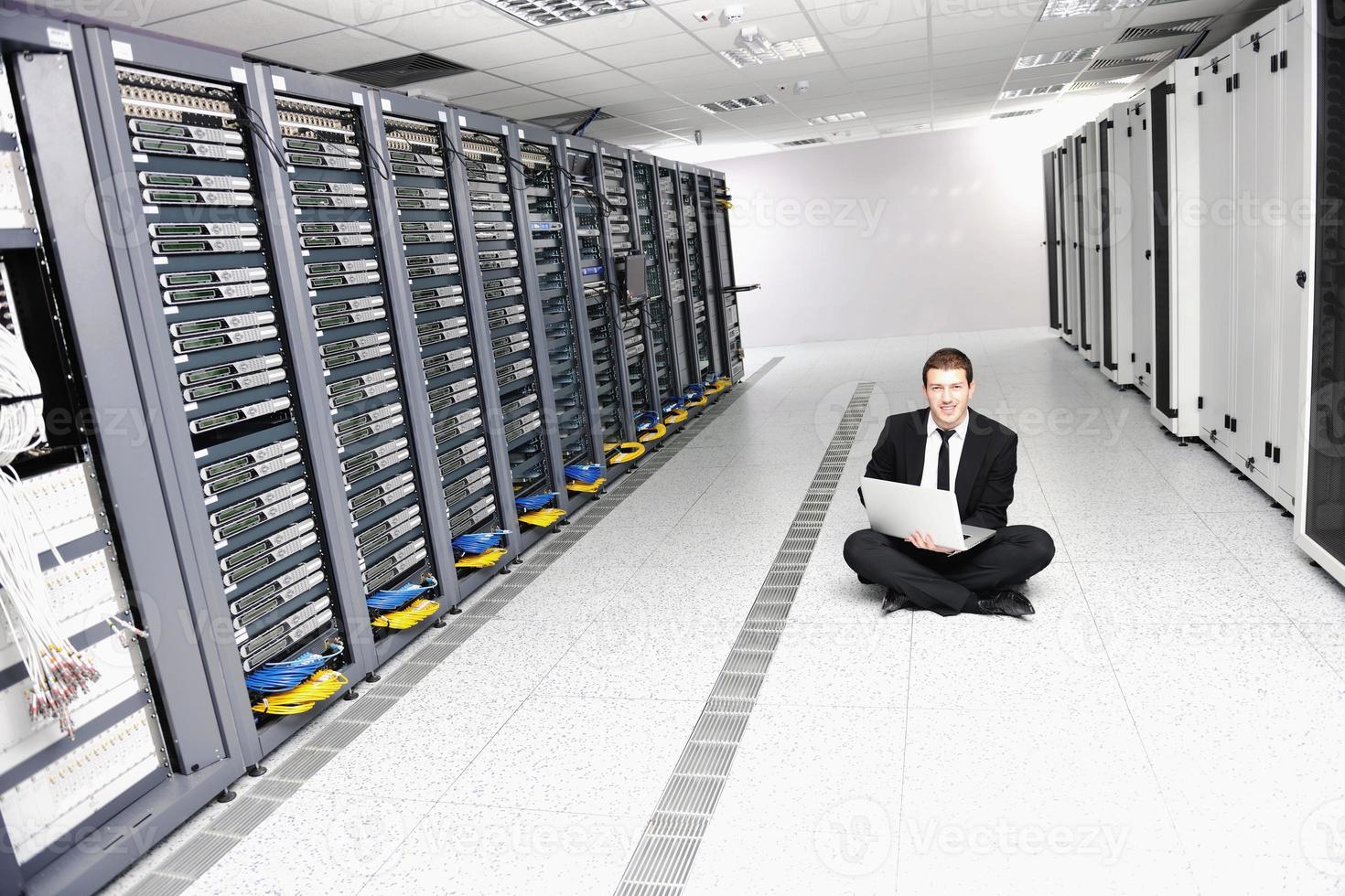 businessman with laptop in network server room photo