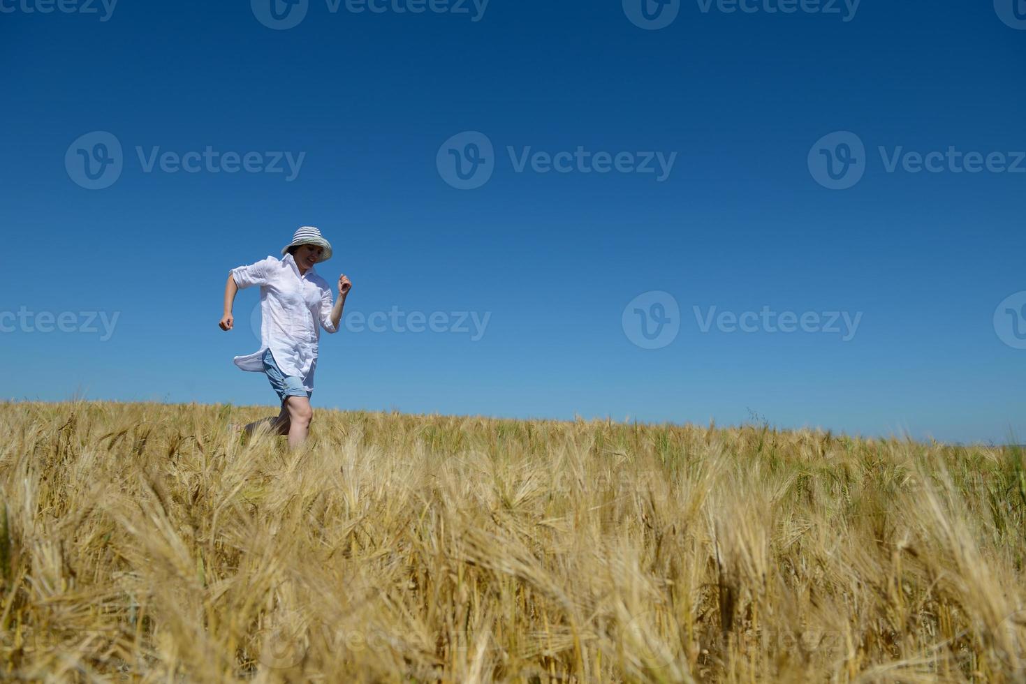 young woman in wheat field at summer photo