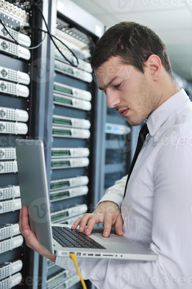 businessman with laptop in network server room photo
