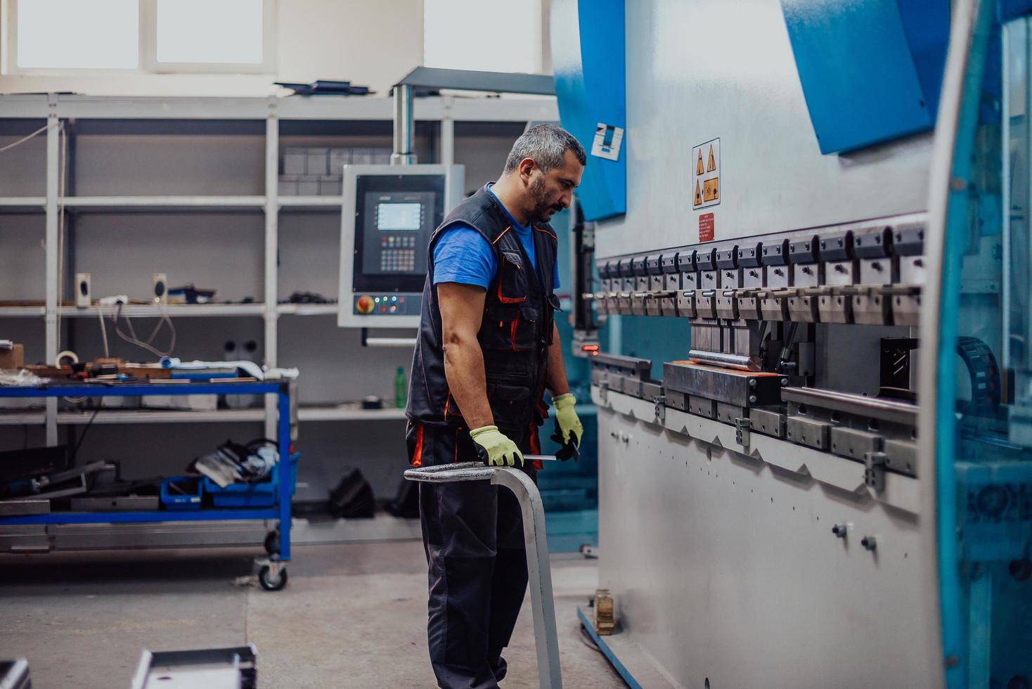 A smart factory worker or engineer makes machines in a production workshop. The concept of industry and engineering. Selective focus photo