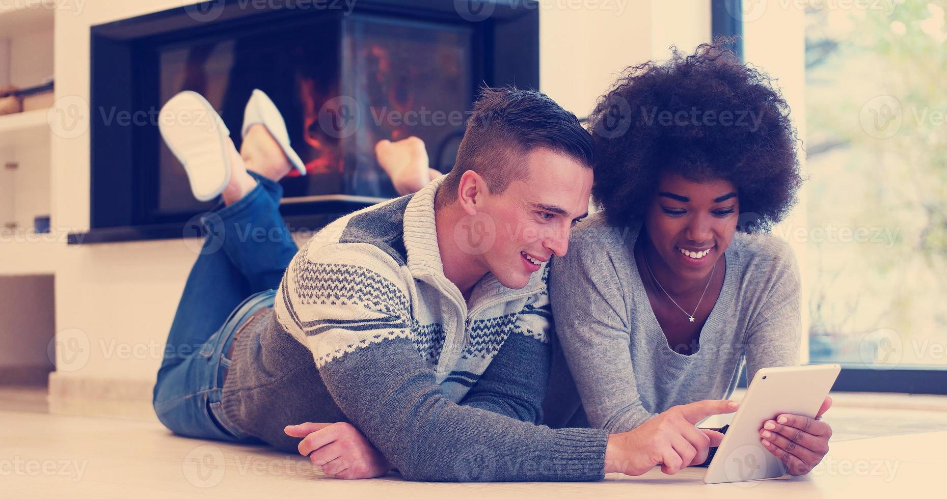 multiethnic couple using tablet computer on the floor photo