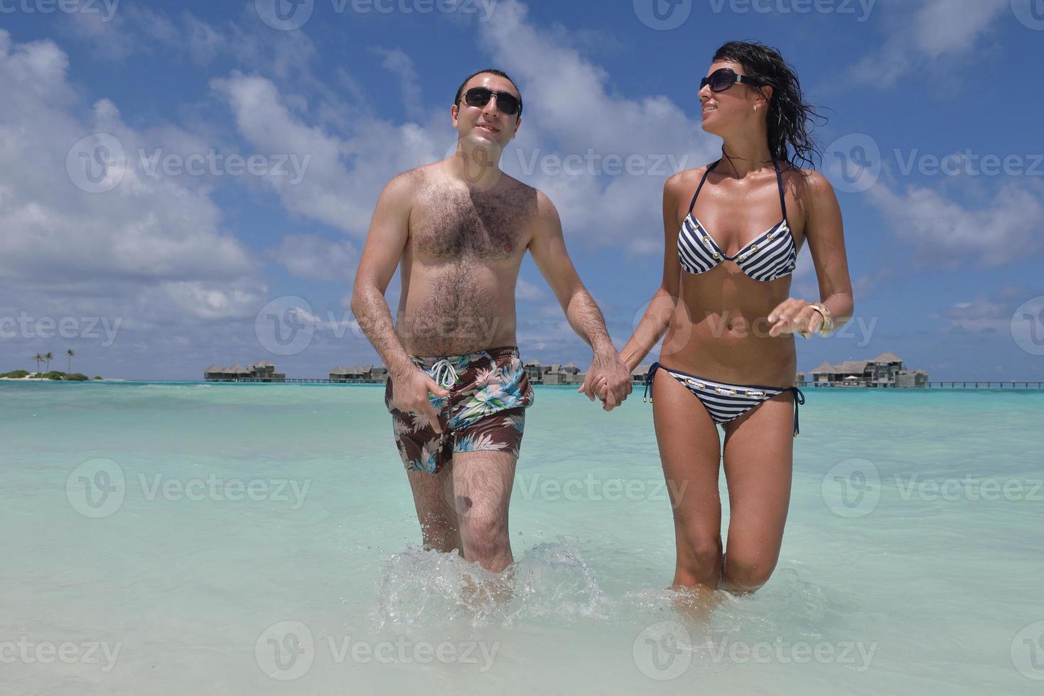 happy young couple have fun on beach photo