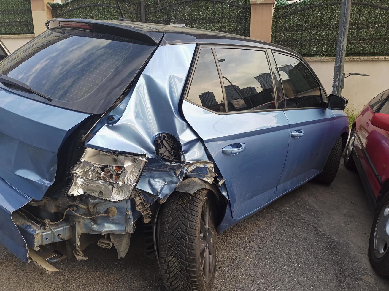 Rear view of a crashed blue hatchback car at street photo