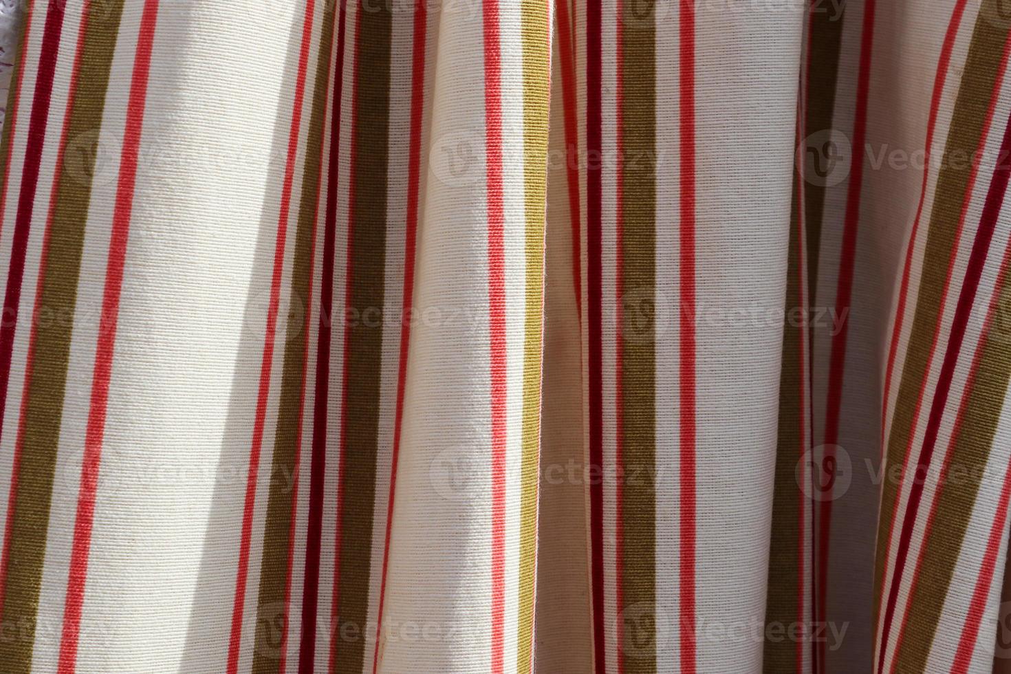 Detailed close up view on samples of cloth and fabrics in different colors found at a fabrics market photo