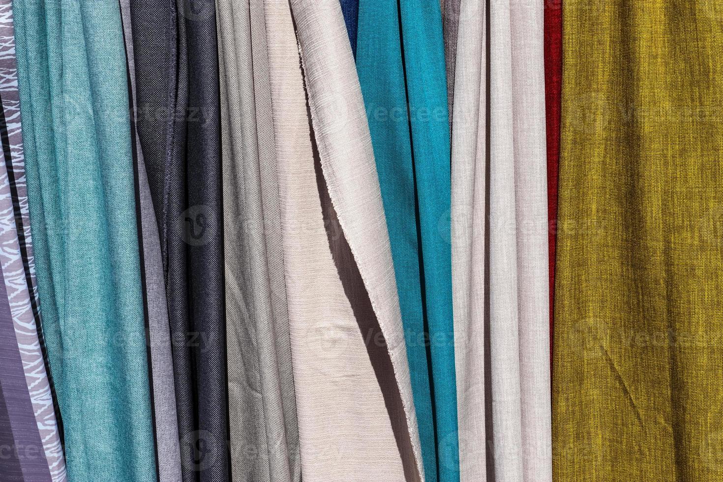 Detailed close up view on samples of cloth and fabrics in different colors found at a fabrics market photo