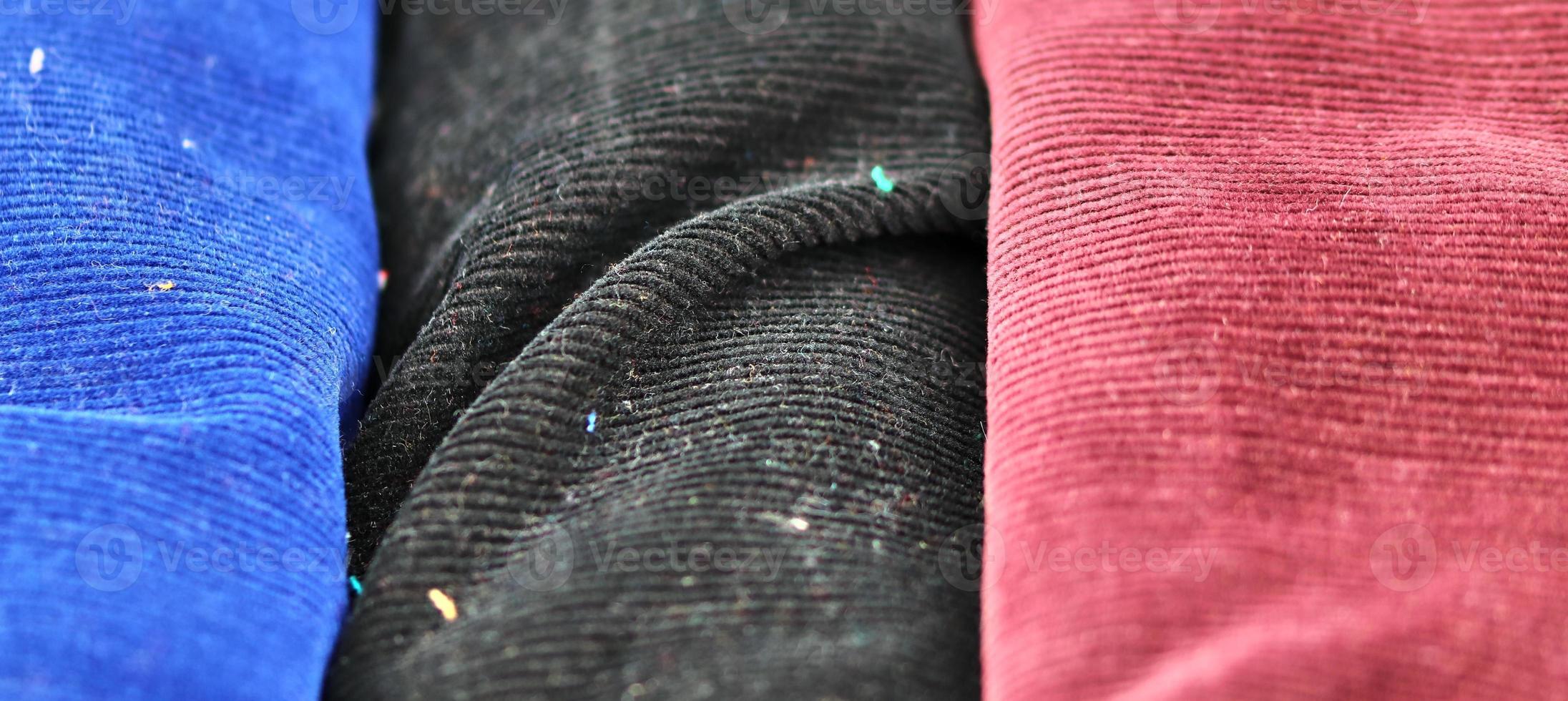 Detailed close up view on samples of cloth and fabrics in different colors found at a fabrics market photo