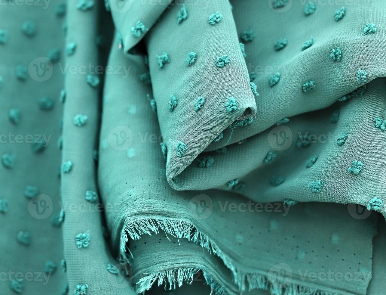 Detailed close up view on samples of cloth and fabrics in different colors found at a fabrics market photo