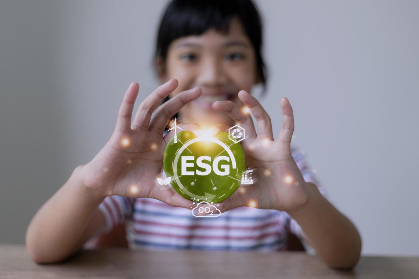 ESG text symbol on kid hands green leaf eco background, creative eco environment investment fund, future green energy innovation business trend.ESG of environmental Icon. photo