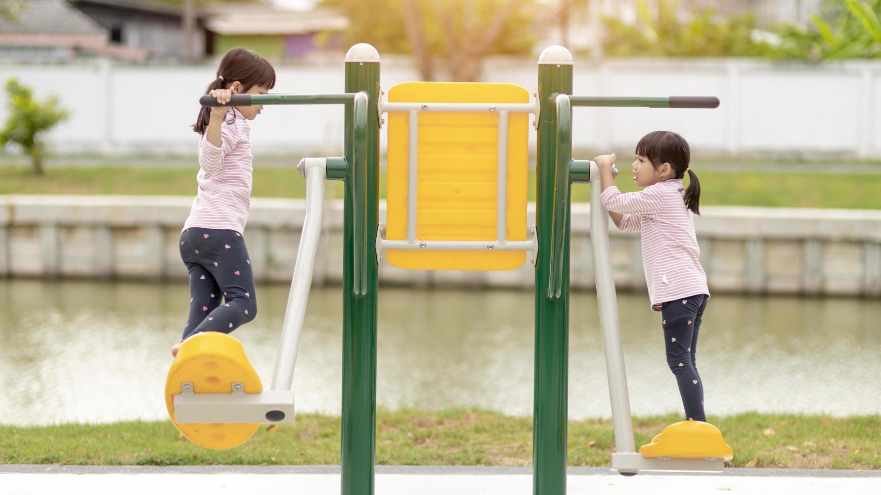 Asian little girl enjoys playing in a children playground, Outdoor portrait photo