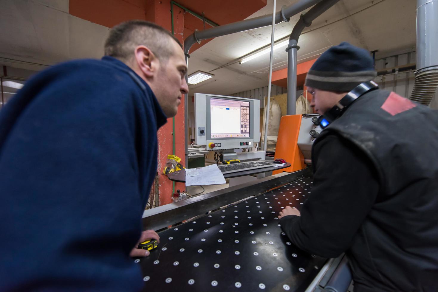 carpenters calculating and programming a cnc wood working machine photo