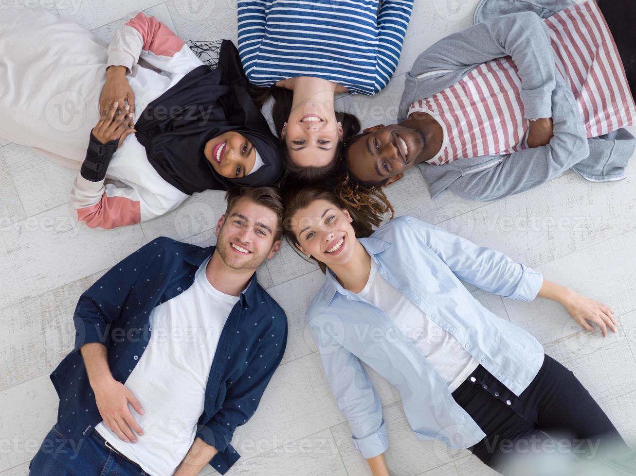 top view of a diverse group of people lying on the floor and symbolizing togetherness photo