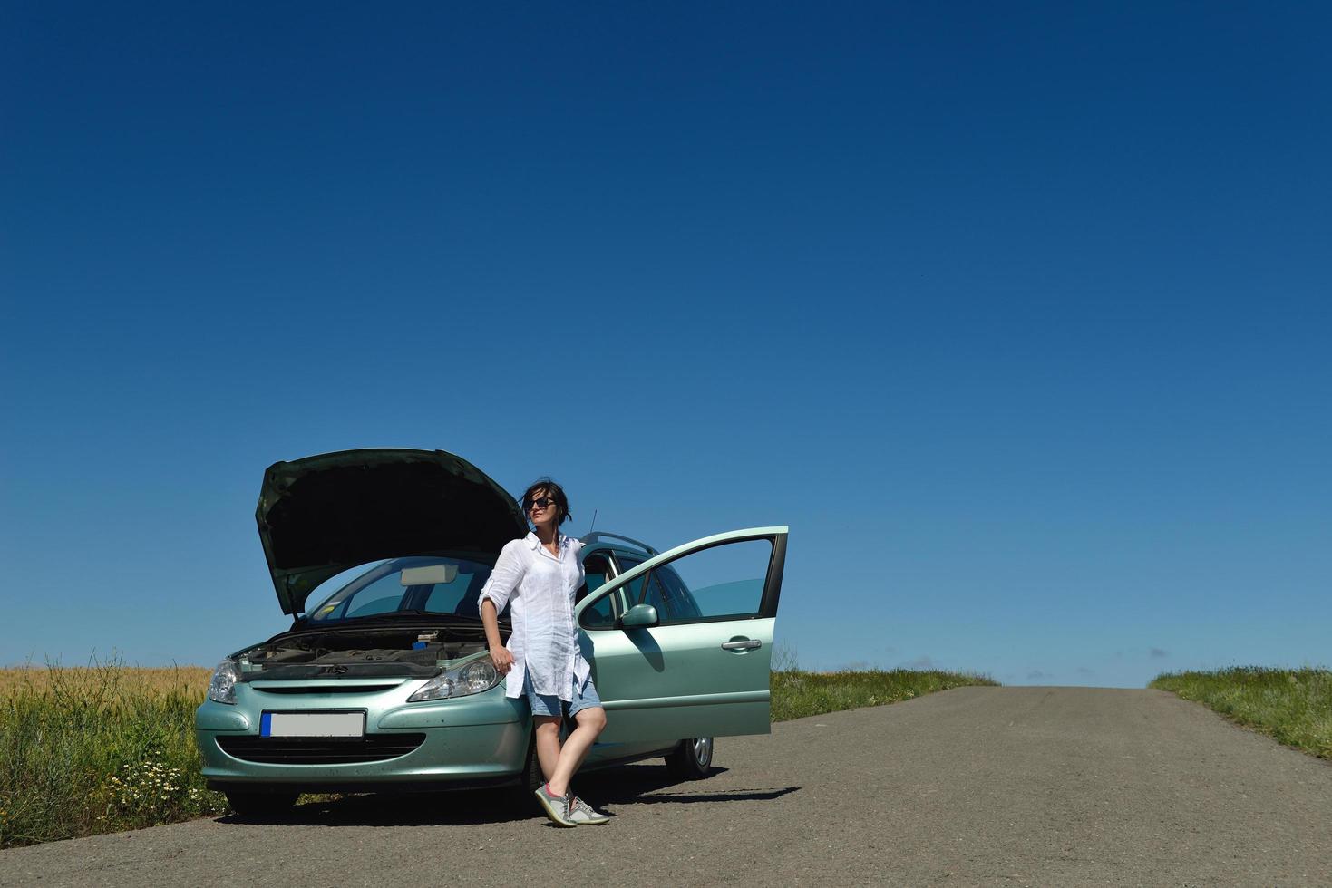 mujer con auto averiado foto