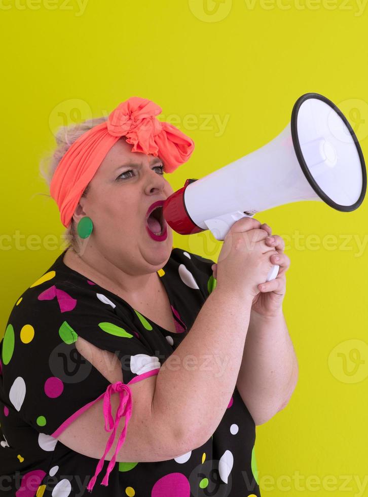 Funny plus size woman woman posing isolated on pastel green background studio portrait. People emotions lifestyle concept. Mock up copy space. Screaming in megaphone. photo