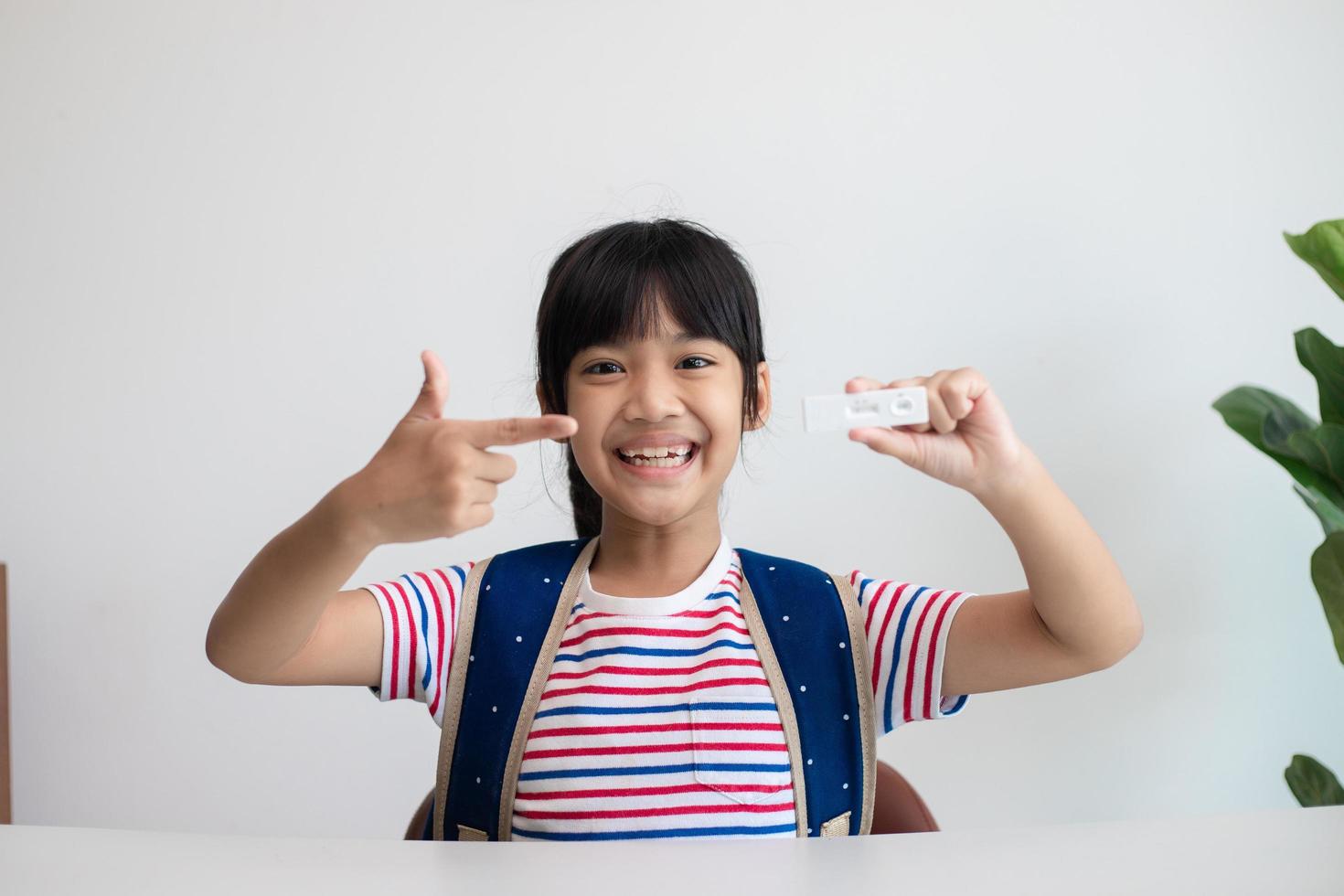 Asian girl is tested for covid-19 before class. photo