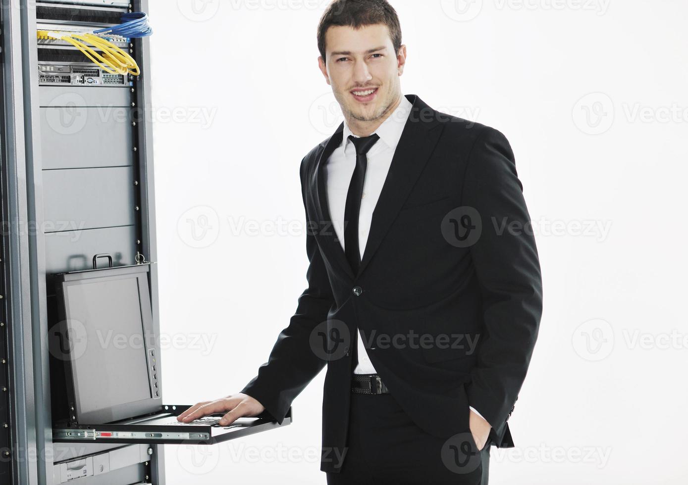 businessman with laptop in network server room photo