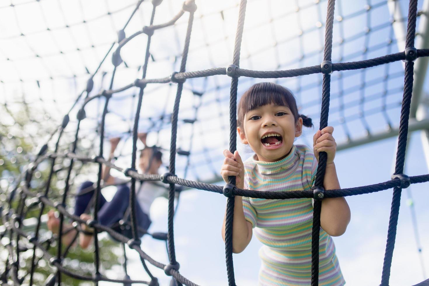 niños pequeños escalando en el patio de la escuela. foto