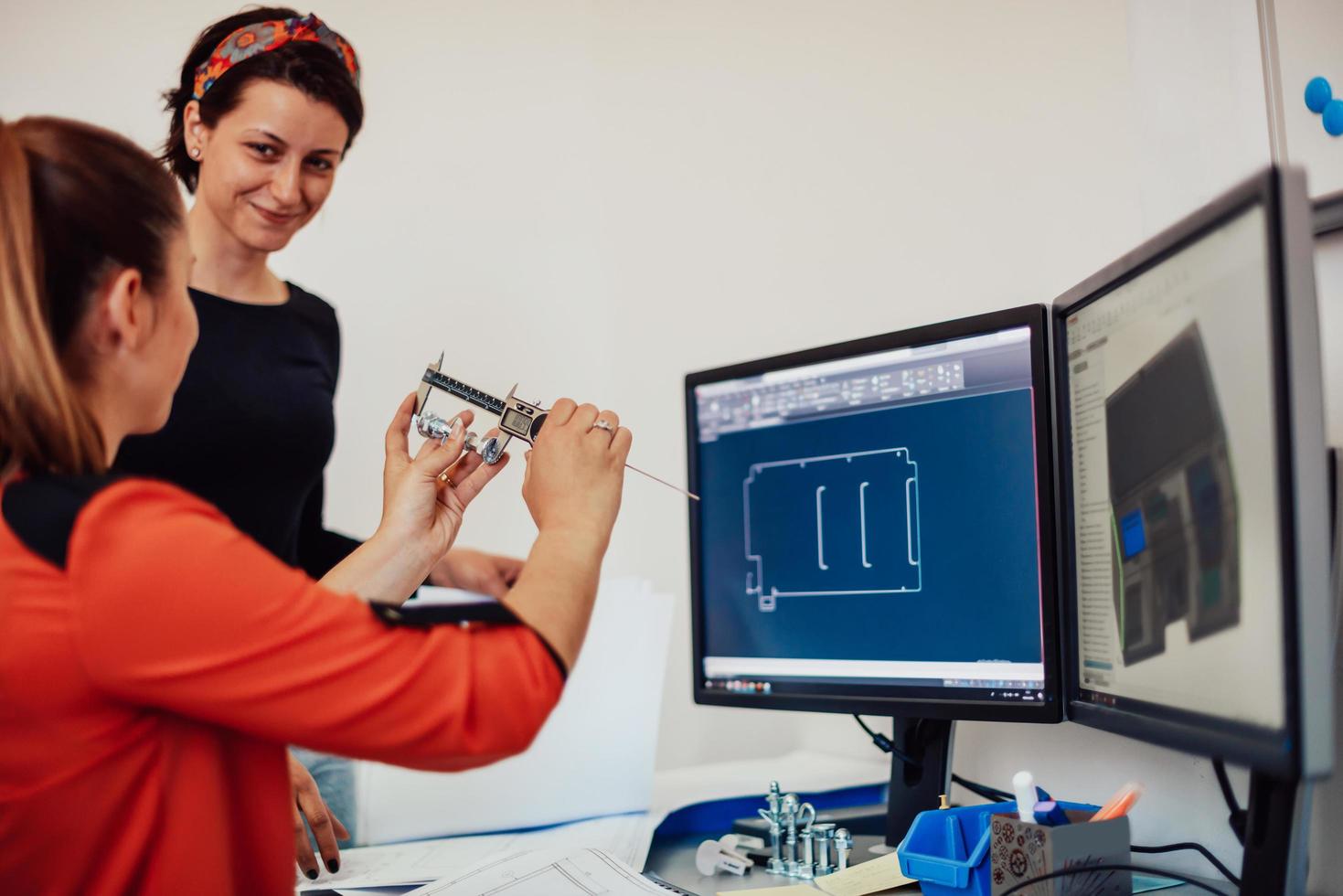 Within the heavy industry, a factory industrial engineer measures with a caliper and on a personal computer Designs a 3D model photo