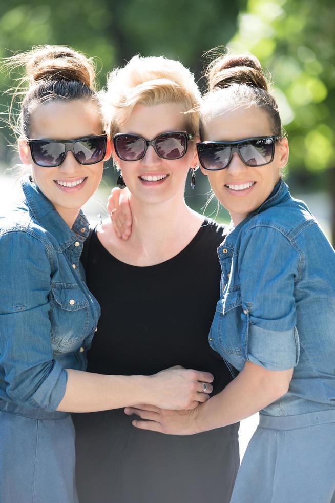 portrait of three young beautiful woman with sunglasses photo