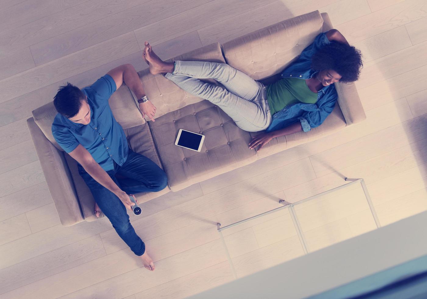 multiethnic couple relaxes in the living room top view photo