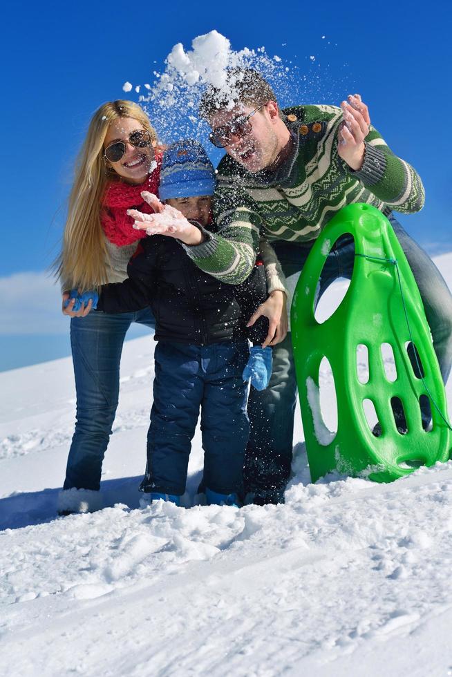 family having fun on fresh snow at winter photo
