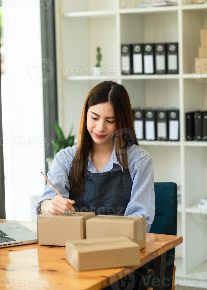 Woman hand using laptop, smartphone and tablet and writing notebook at office of her business online shopping. In home photo