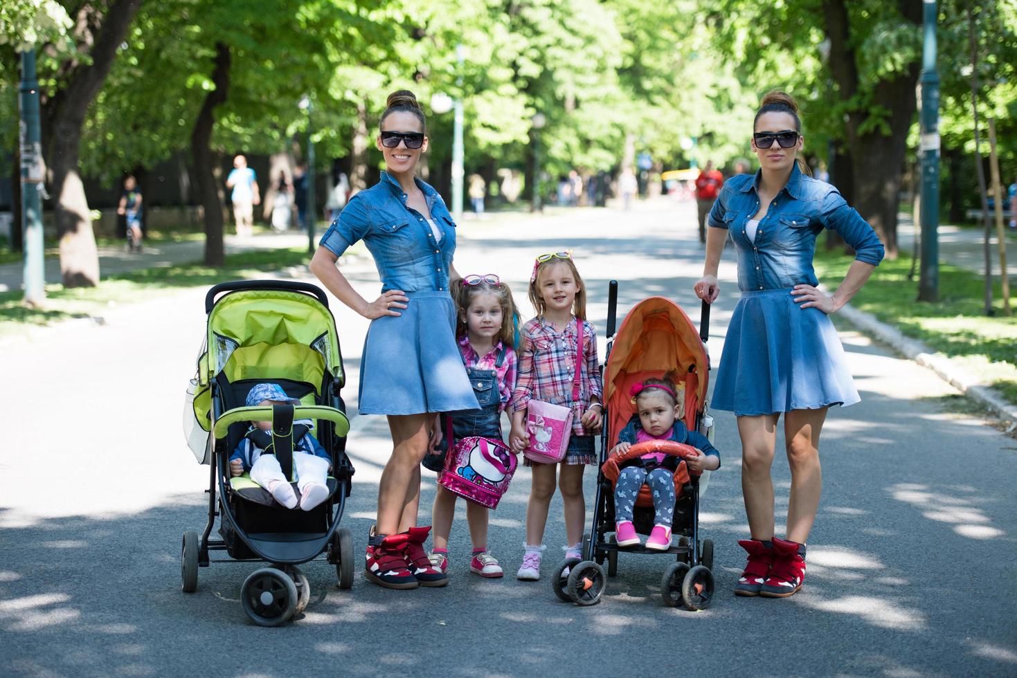 twins mother with children  in city park photo