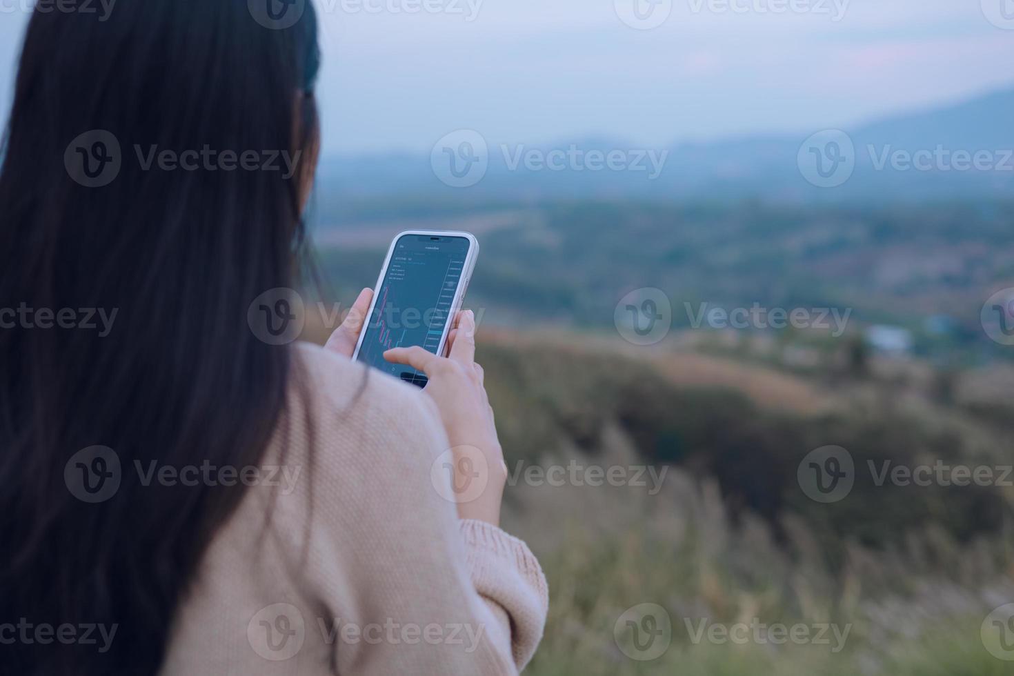 Woman is checking Bitcoin price chart on digital exchange on smartphone, cryptocurrency future price action prediction. photo