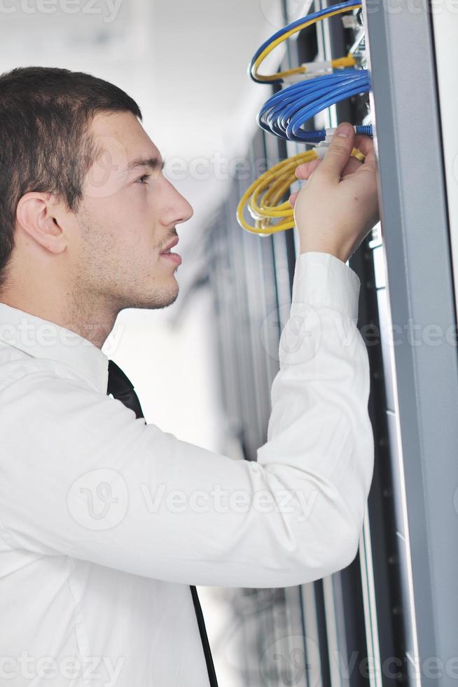 young engeneer in datacenter server room photo