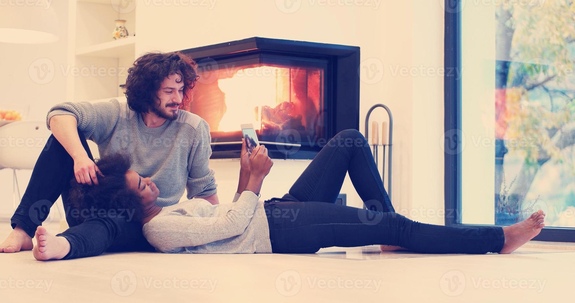 multiethnic couple using tablet computer on the floor photo