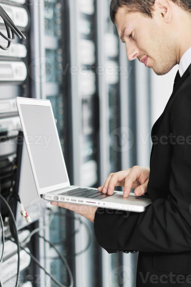 businessman with laptop in network server room photo