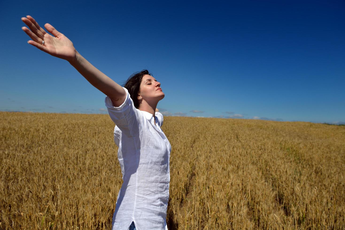 young woman in wheat field at summer photo