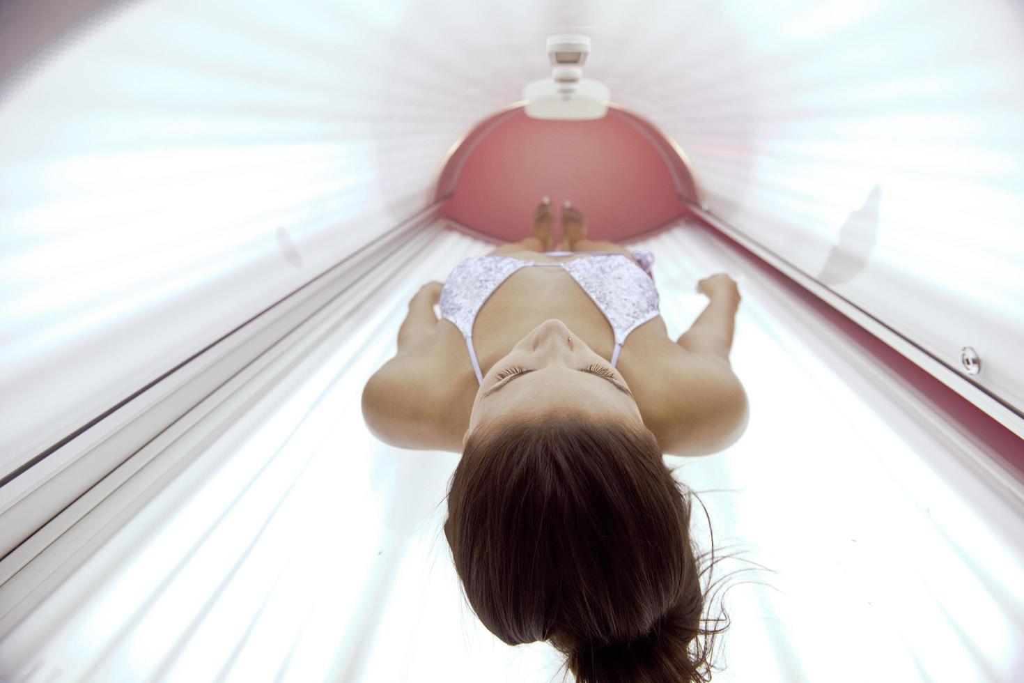 bella joven bronceándose en el solarium foto