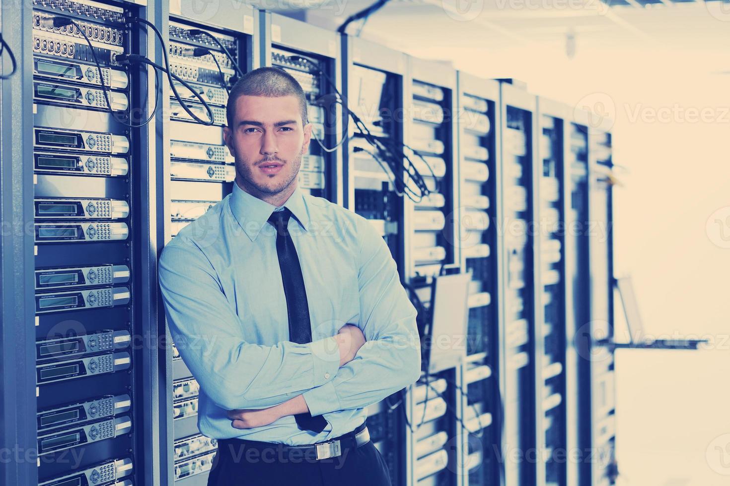 businessman with laptop in network server room photo