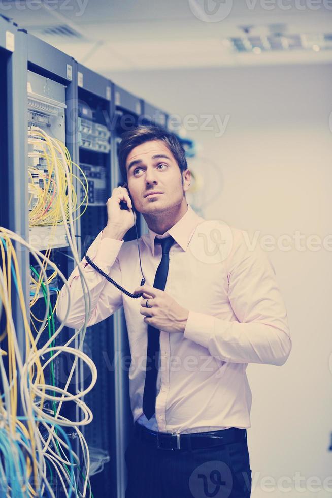 it engeneer talking by phone at network room photo