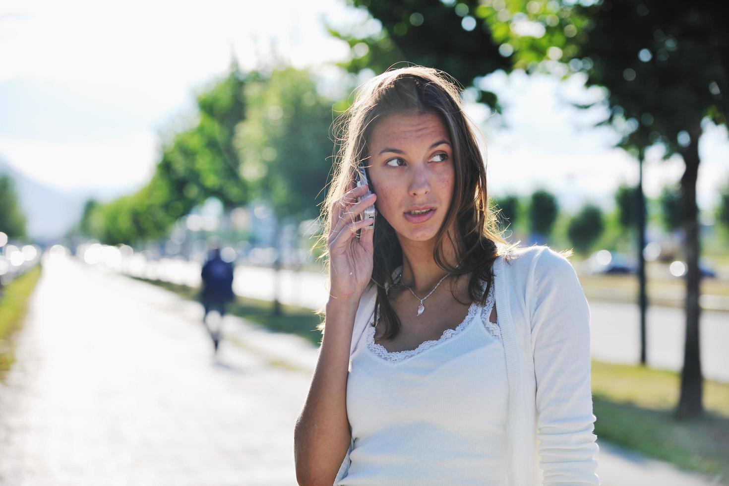 young woman talk by cellphone on street photo