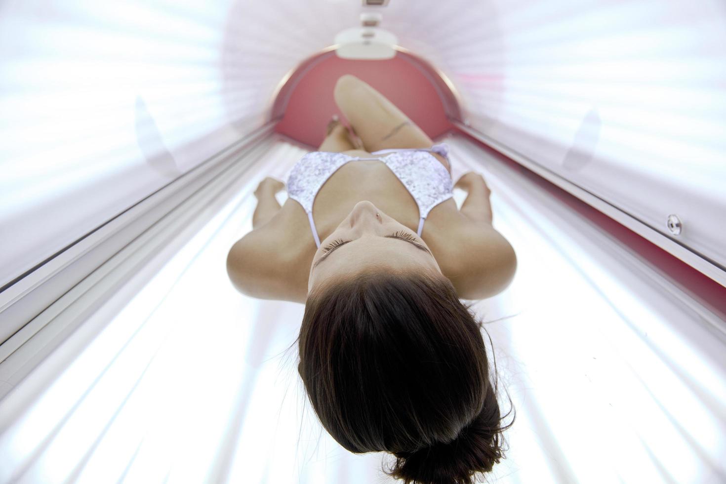 bella joven bronceándose en el solarium foto