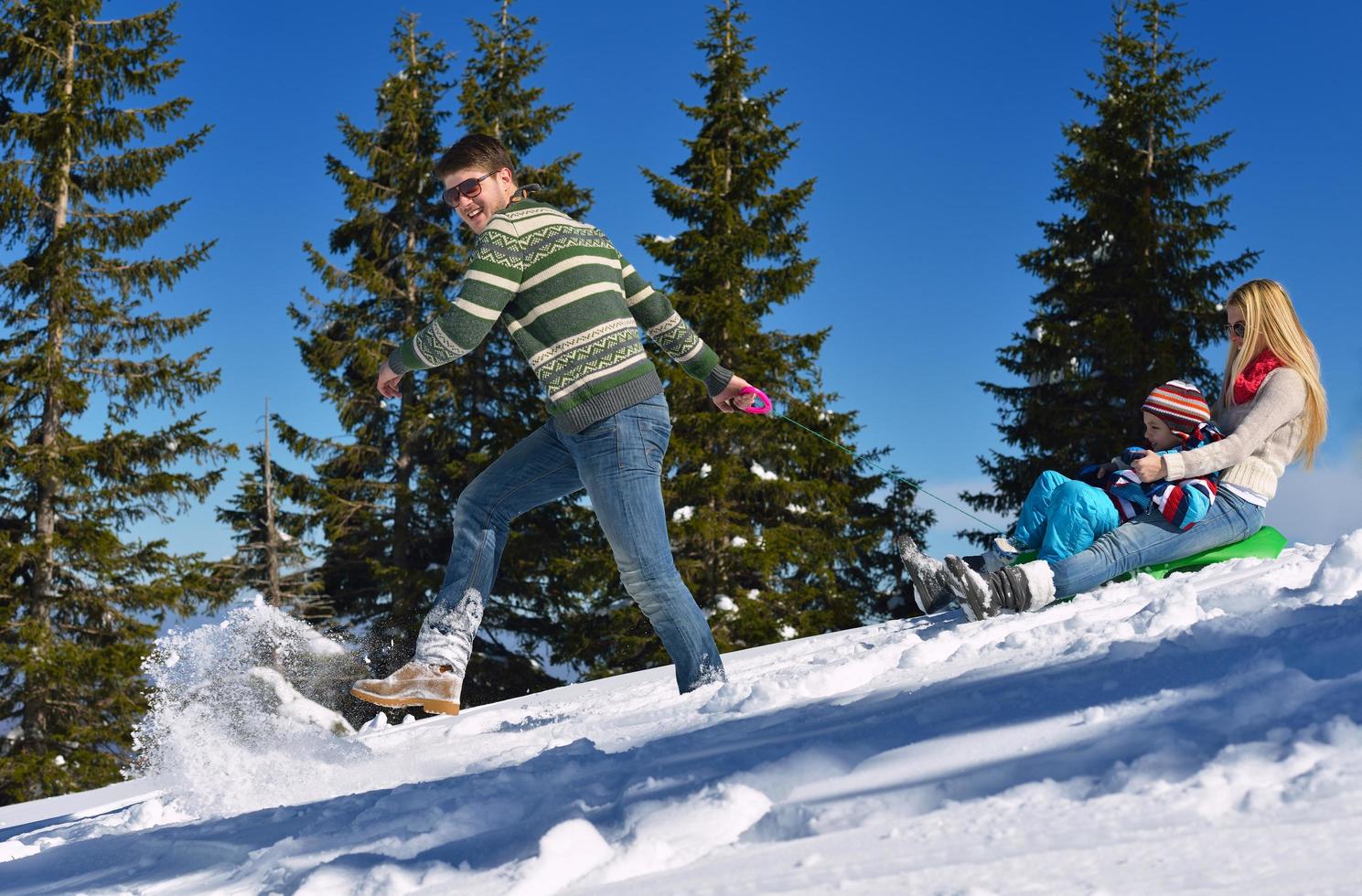 family having fun on fresh snow at winter photo