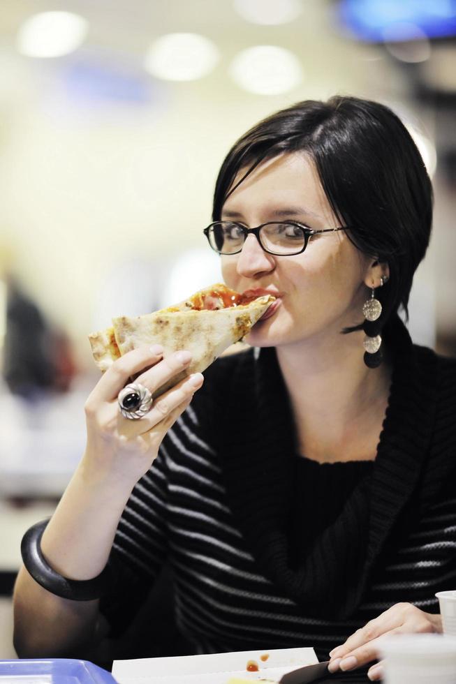 mujer come pizza en el restaurante foto