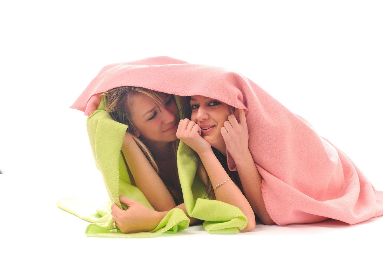 young girls under blanket smile photo
