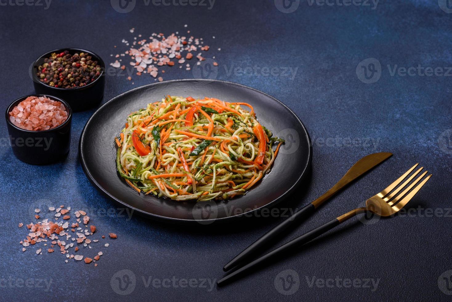Fresh salad of sliced thin strips of carrot and zucchini on a concrete background photo