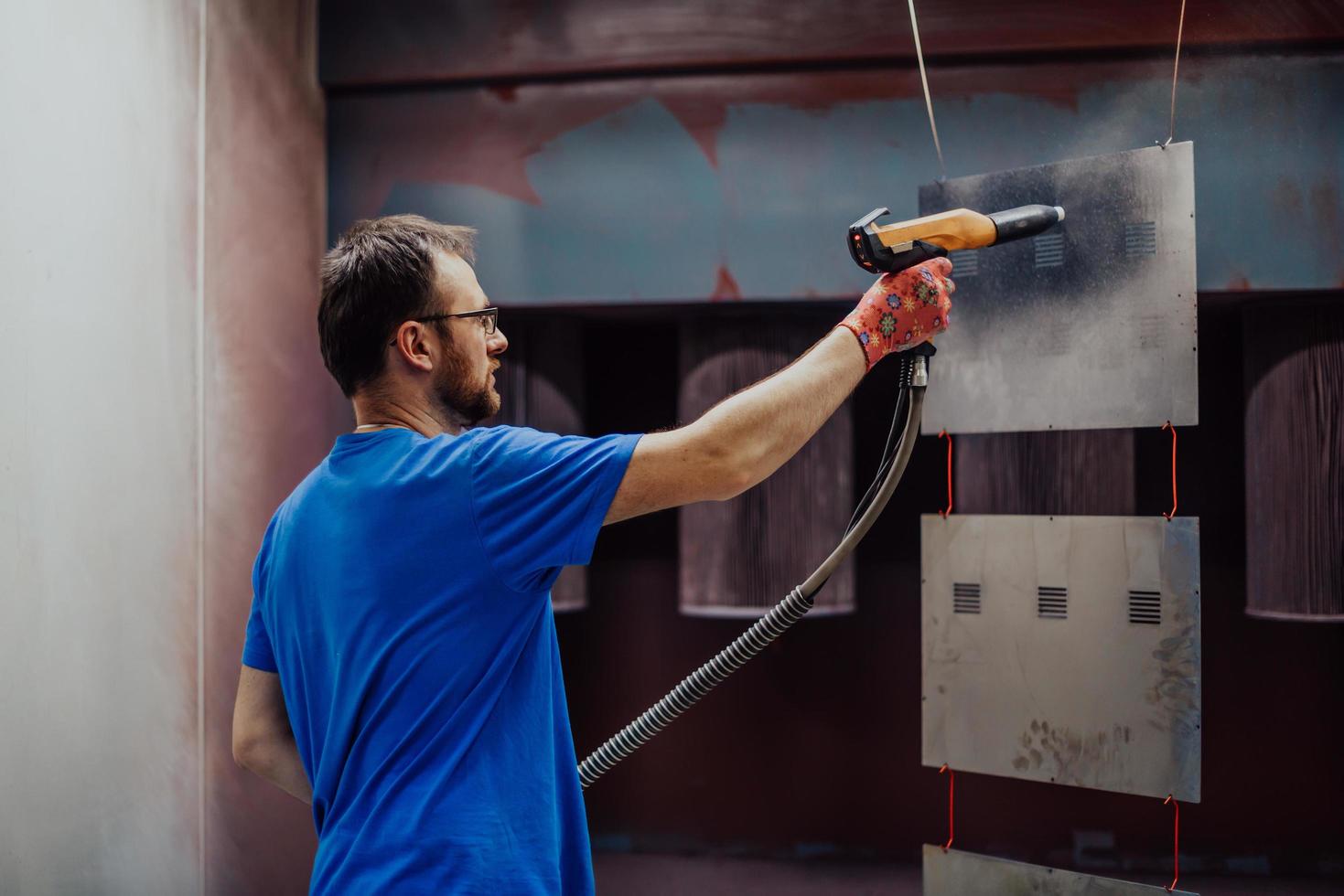 The painter paints the iron element. Industrial painting parts. Metal designs photo