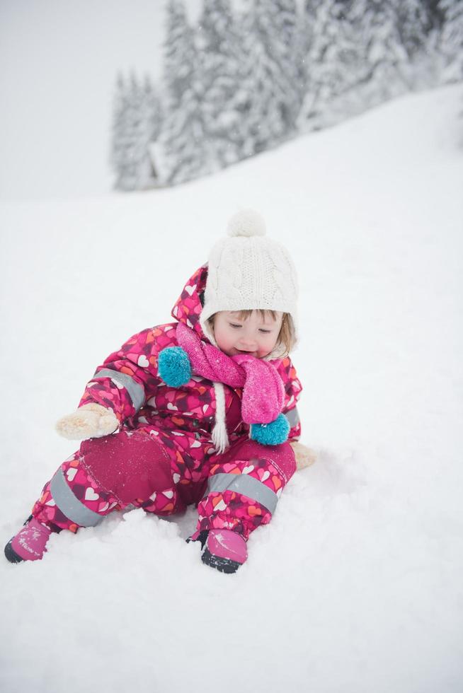 la niña se divierte en el día de invierno nevado foto