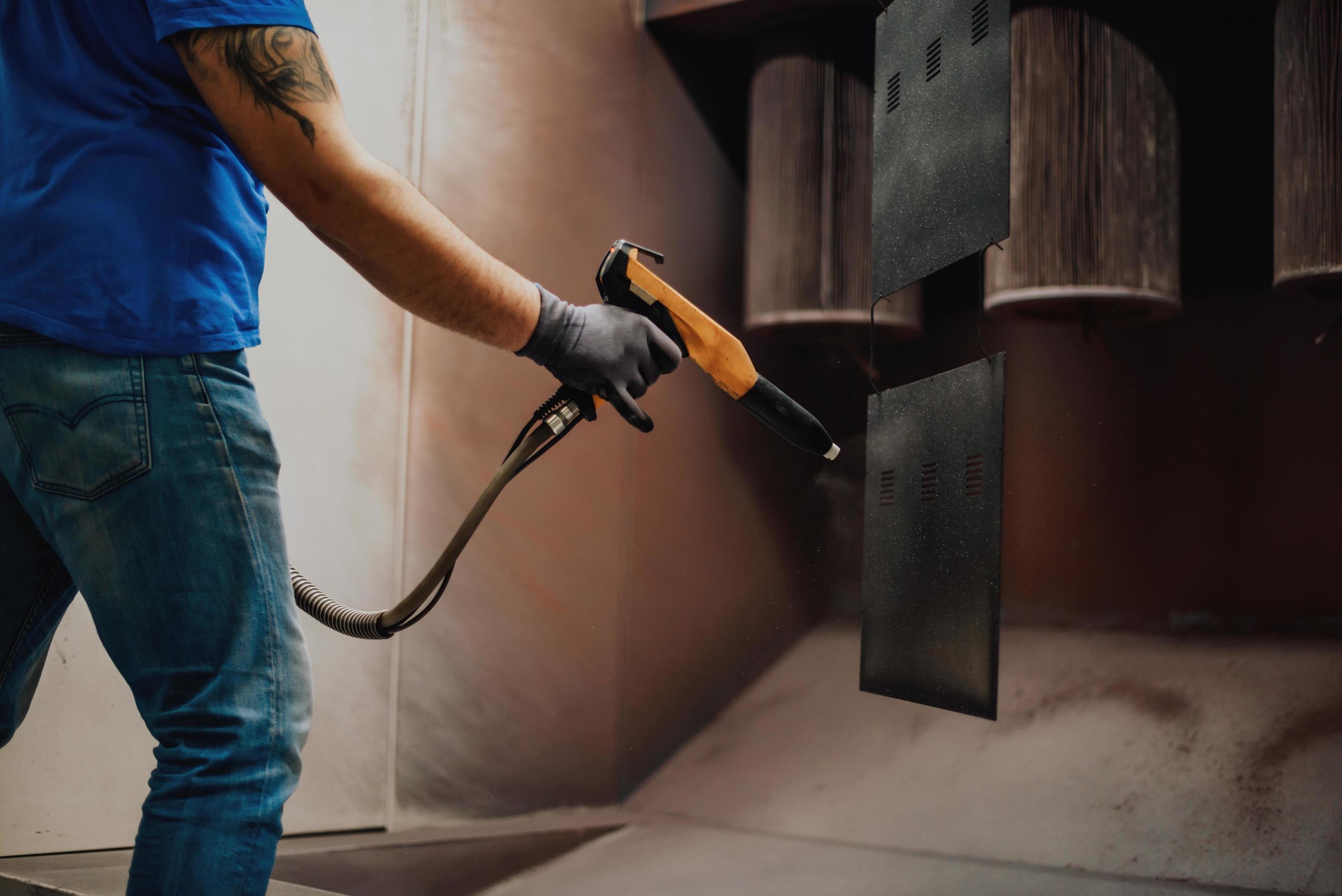 The painter paints the iron element. Industrial painting parts. Metal