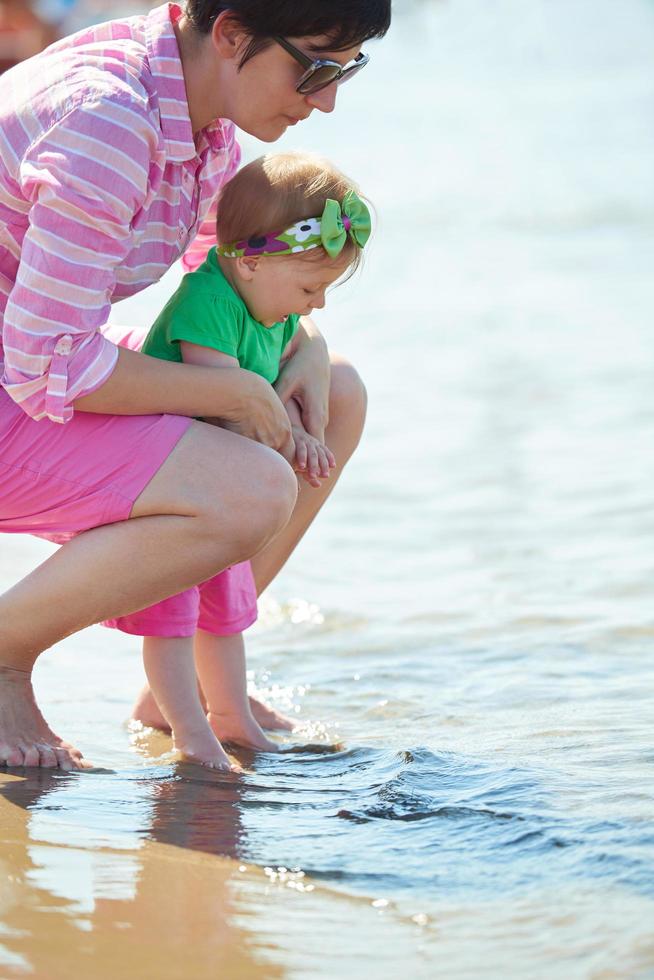 mamá y bebé en la playa se divierten foto